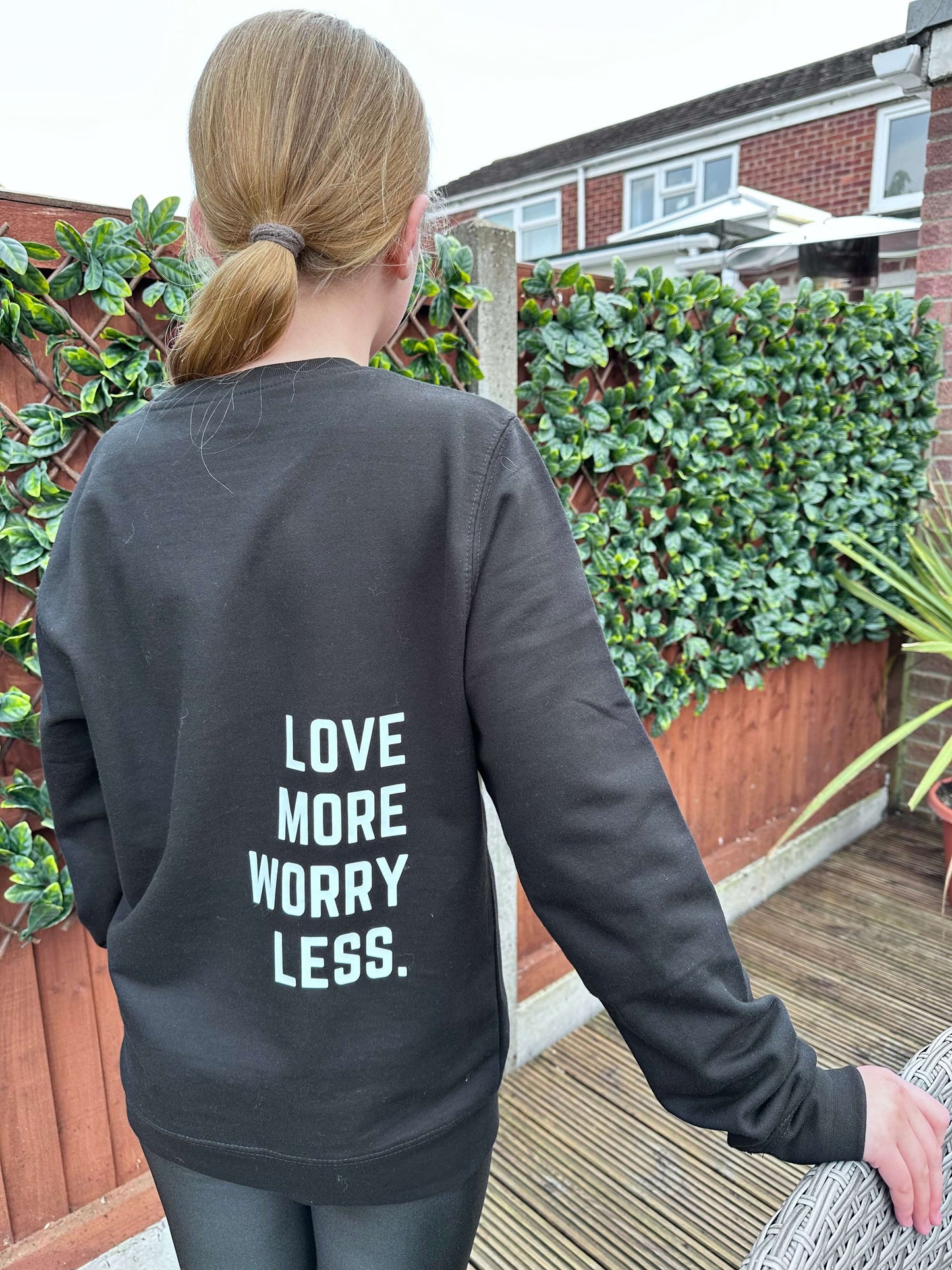 Black crew neck sweater with Love more worry less design